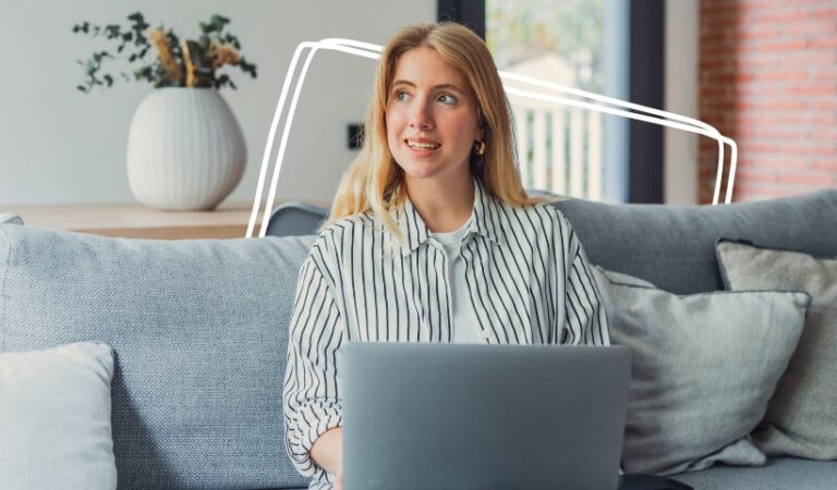 Woman sitting on a couch with a laptop, learning how to sell digital products on Etsy