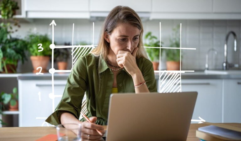 Small business owner reviewing budget and financial data on laptop